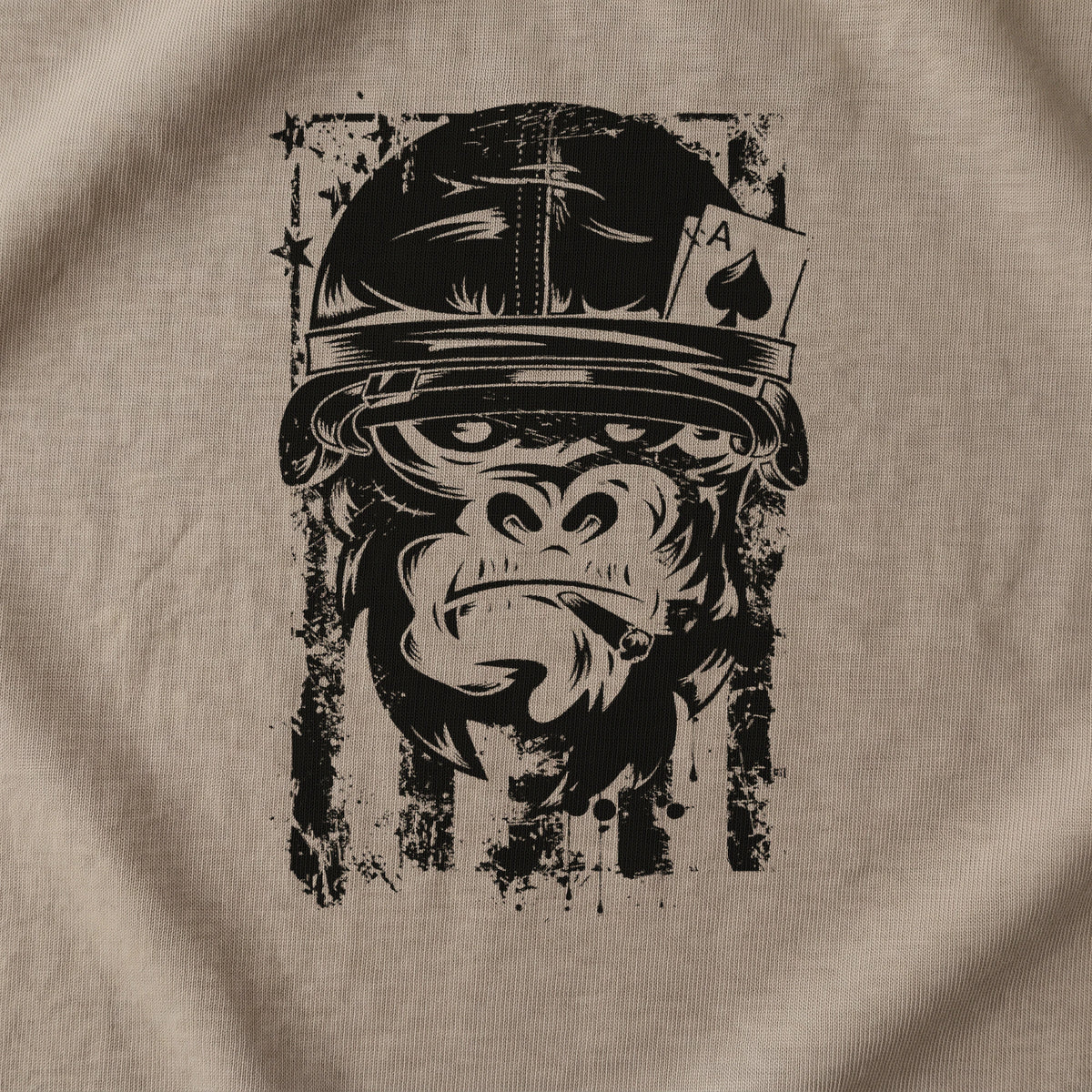 Close-up of the American Gorilla Ace of Spades T-Shirt front print on Brown Savana: the helmeted gorilla, the ace of spades card, the cigar and the distressed flag stripes in black (digitally composited print visualization, not a photograph)