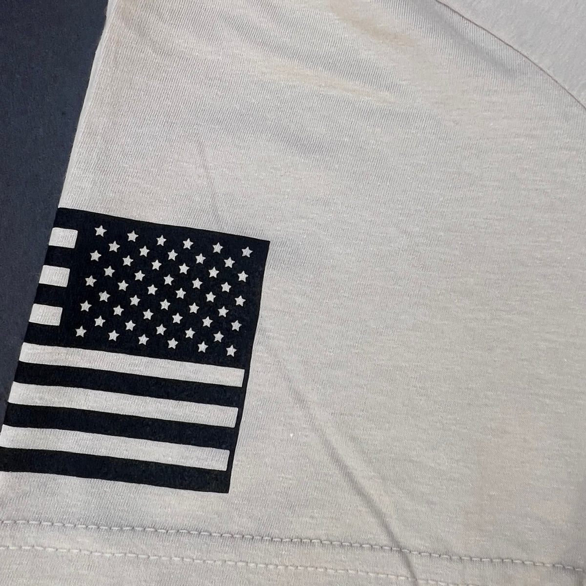 Close-up of the printed American flag on the right sleeve of the Sand American Warrior Skull T-Shirt, actual production print