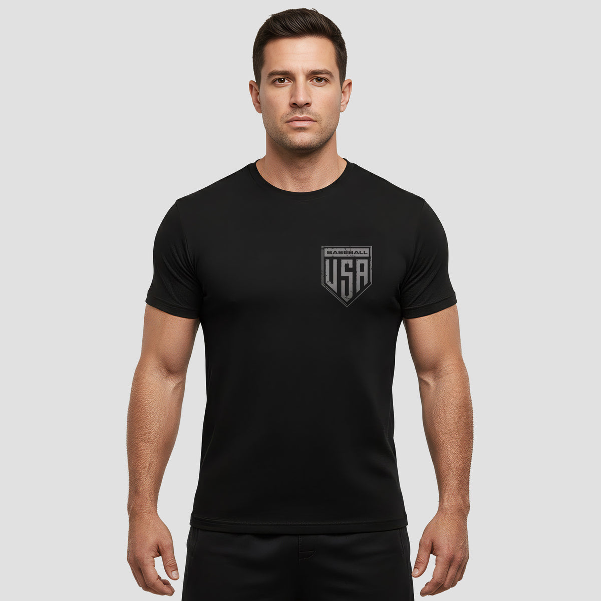 Man wearing a black t-shirt with a logo on a gray background