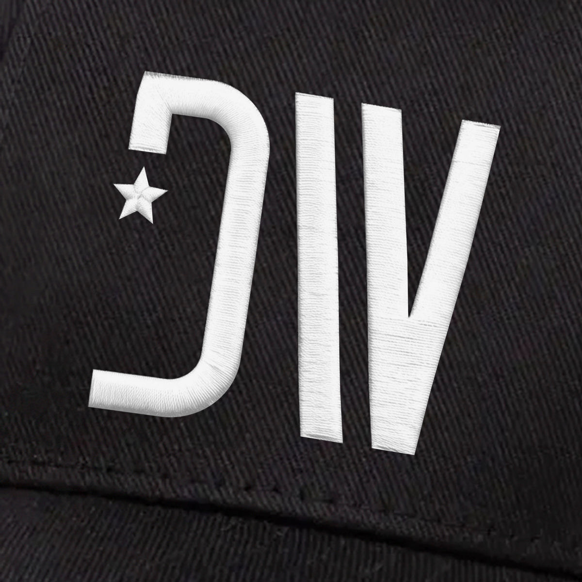Close-up of the raised white 3D puff DW star monogram stitching on the black Dion Wear Logo Stretch Fit Cap