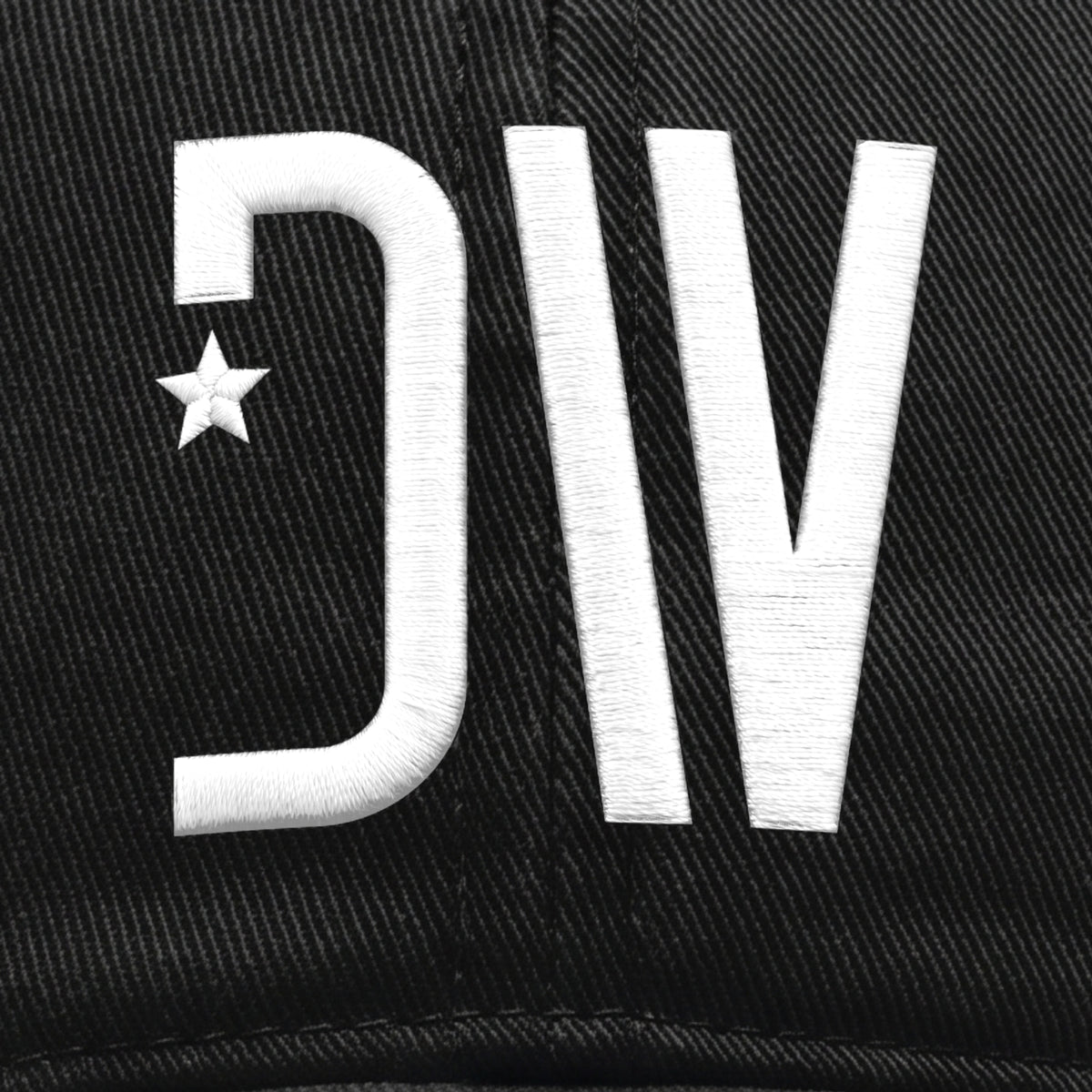Close-up of the raised white 3D puff DW star embroidery on the black peached cotton twill cap