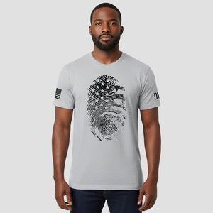 Man wearing a gray t-shirt with a fingerprint design on a plain background