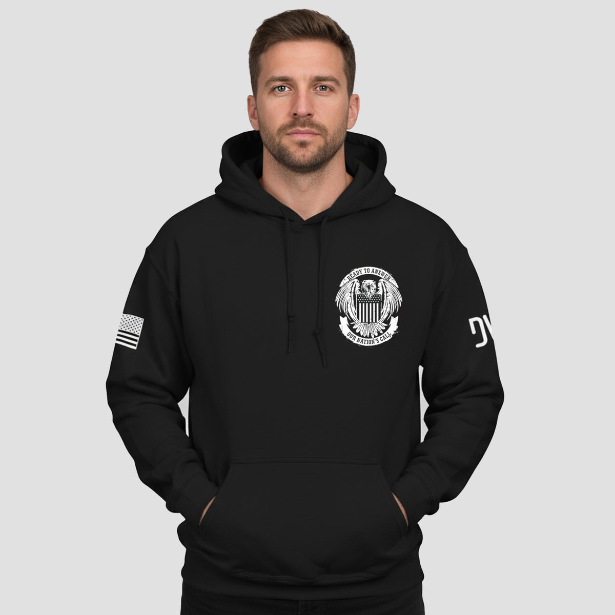 Man wearing a black hoodie with logos on a light gray background