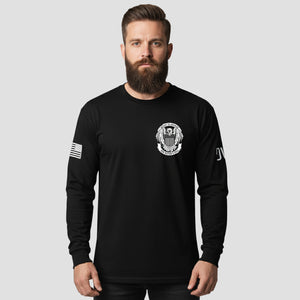 Man wearing a black long-sleeve shirt with logos on a light gray background