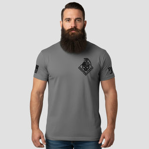 Man wearing a gray t-shirt with a logo on a light gray background