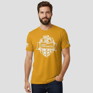 Man wearing a mustard yellow t-shirt with a graphic design on a plain background