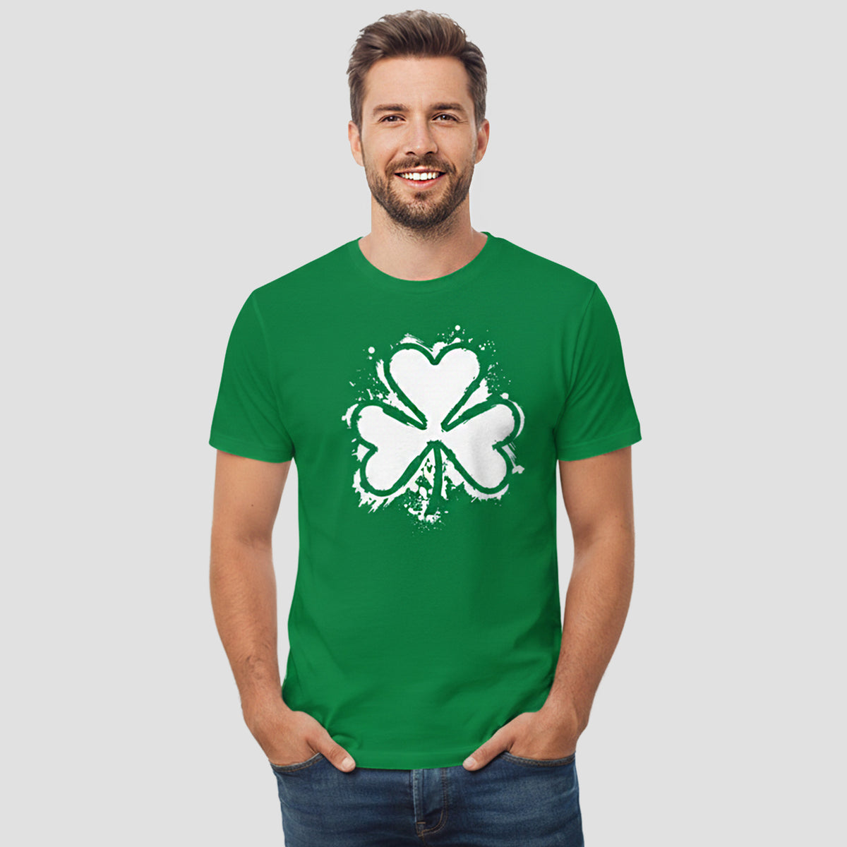 Man wearing a green t-shirt with a white shamrock design on a light gray background