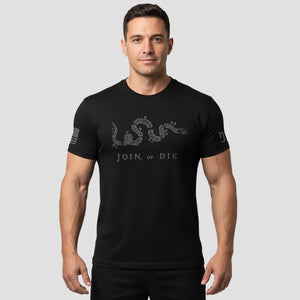 Man wearing a black t-shirt with text and graphics on a light gray background