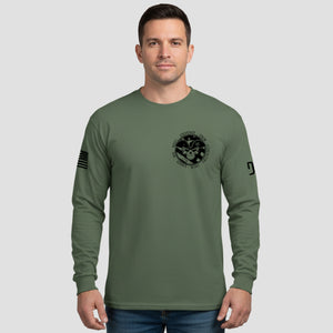 Man wearing a green long-sleeve shirt with a logo on a gray background