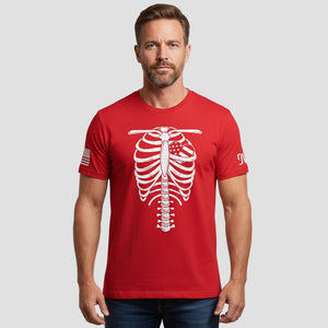 Man wearing a red t-shirt with a white skeleton design on a plain background