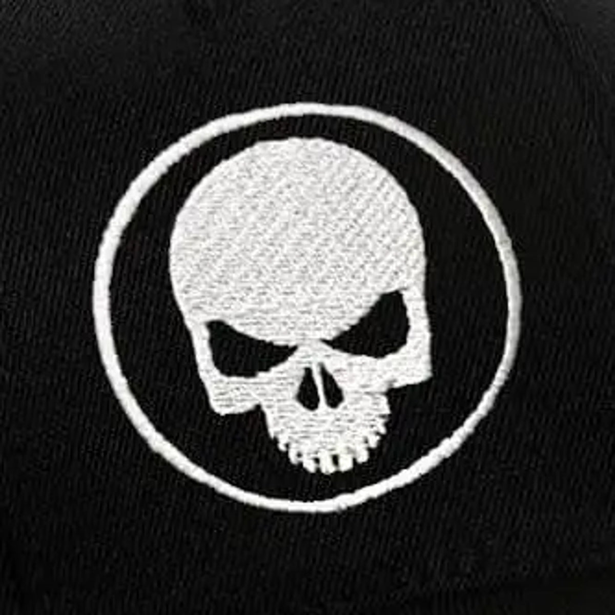 Close-up of the white skull-and-ring embroidery on the black Skull Stretch Fit Cap