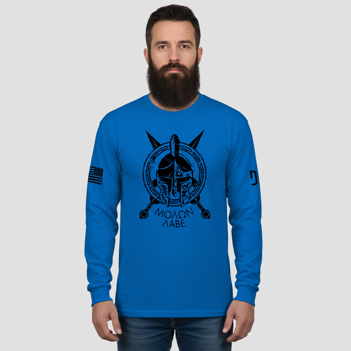 Man wearing a blue long-sleeve shirt with a graphic design on a gray background