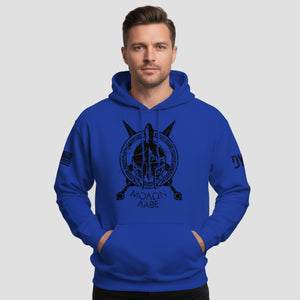 Man wearing a blue hoodie with a black graphic design on a light gray background