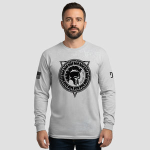 Man wearing a gray long-sleeve shirt with a black graphic design on a light gray background